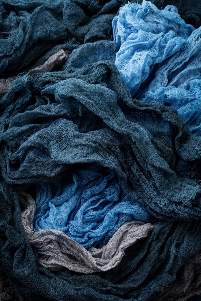 Crumpled blue textile fabrics ready for sorting and recycling.
